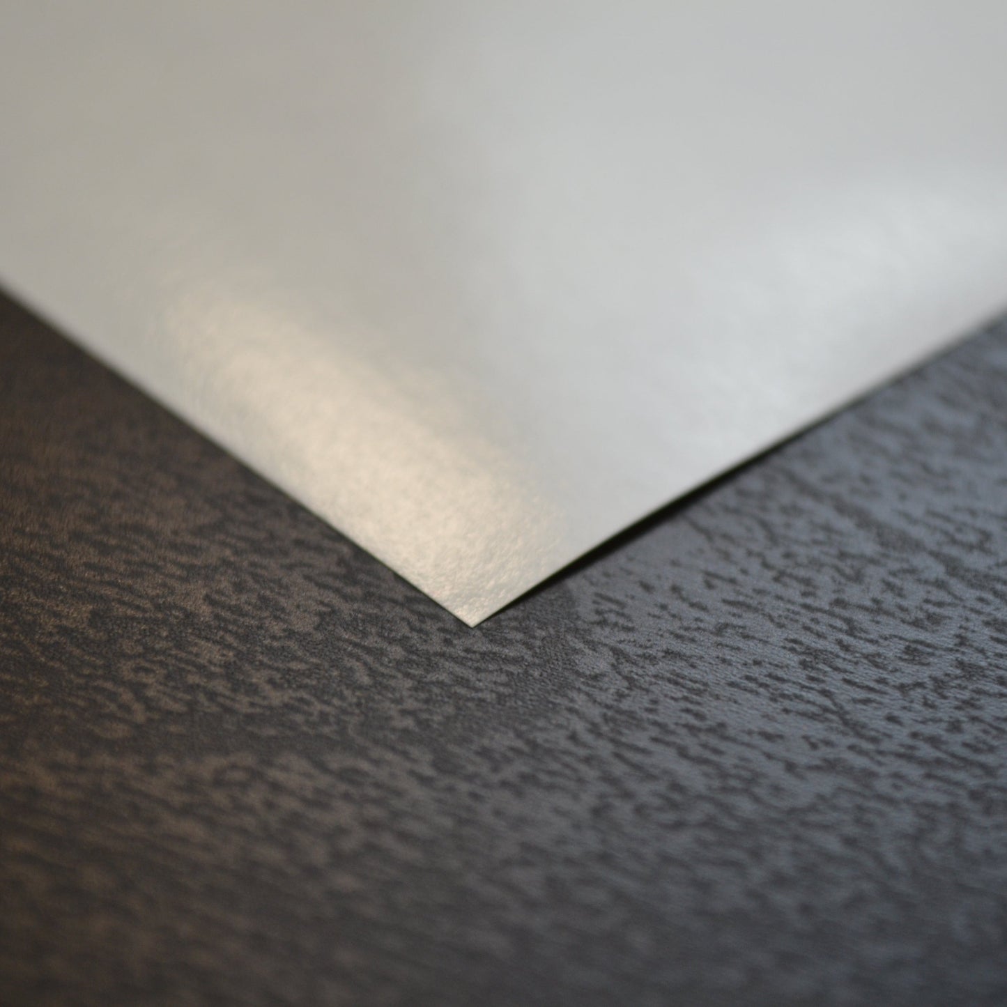 White sheet of paper on a textured dark surface