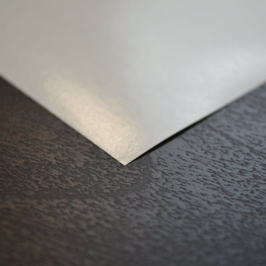 White sheet of paper on a textured dark surface